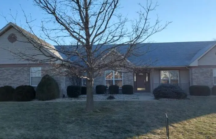 Brick and siding ranch home with a large front-yard tree