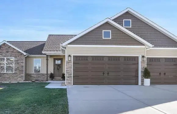 Stone and siding home with a three-car garage